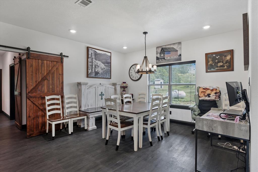 403 Polk Road Bowie, TX 76230 - Photo 12 of 36 Dining area with dark wood-style flooring, a chandelier, recessed lighting, and a barn door