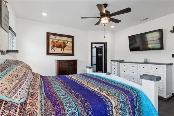 a bedroom with a large bed and a flat screen tv
