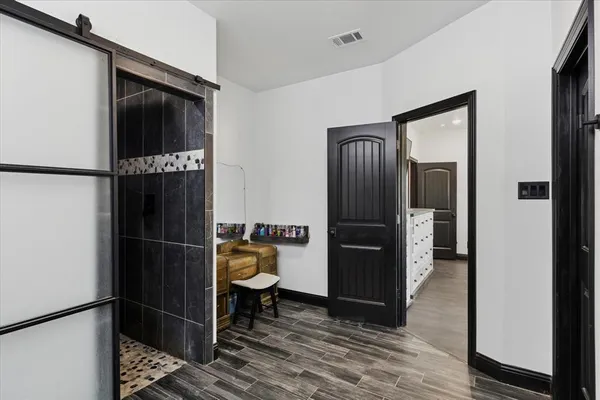 a walk in closet with wooden floor