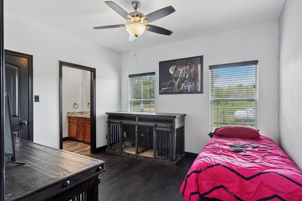 403 Polk Road Bowie, TX 76230 - Photo 18 of 36 Bedroom featuring dark wood-style flooring, connected bathroom, and a ceiling fan