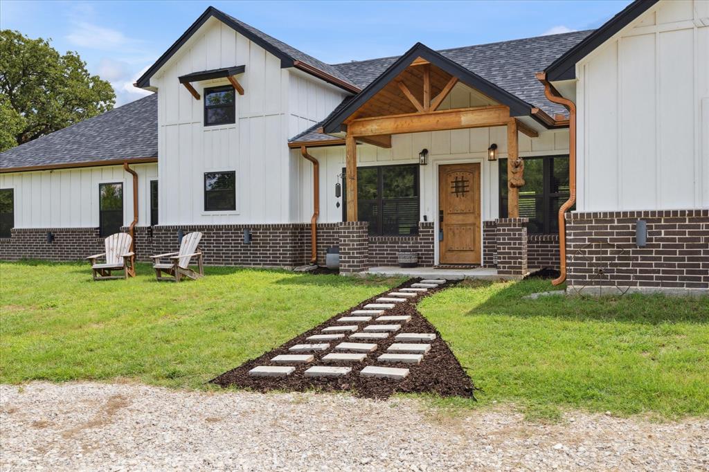 403 Polk Road Bowie, TX 76230 - Photo 2 of 36 Modern farmhouse with board and batten siding, a shingled roof, and a front lawn