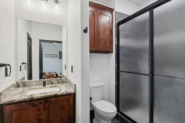 a bathroom with a granite countertop sink toilet and shower