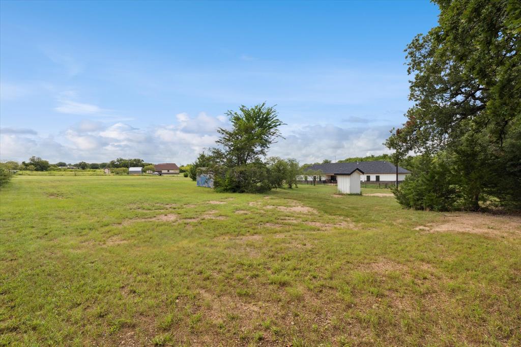 403 Polk Road Bowie, TX 76230 - Photo 36 of 36 View of grassy yard featuring a storage unit