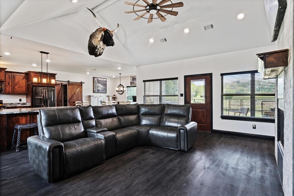 403 Polk Road Bowie, TX 76230 - Photo 4 of 36 Living area featuring a barn door, vaulted ceiling, ceiling fan, dark wood-type flooring, and recessed lighting