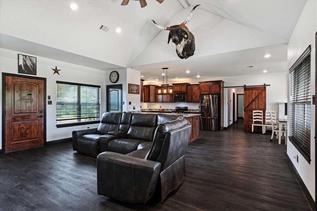 403 Polk Road Bowie, TX 76230 - Photo 6 of 36 Living room with a barn door, dark wood finished floors, recessed lighting, and high vaulted ceiling