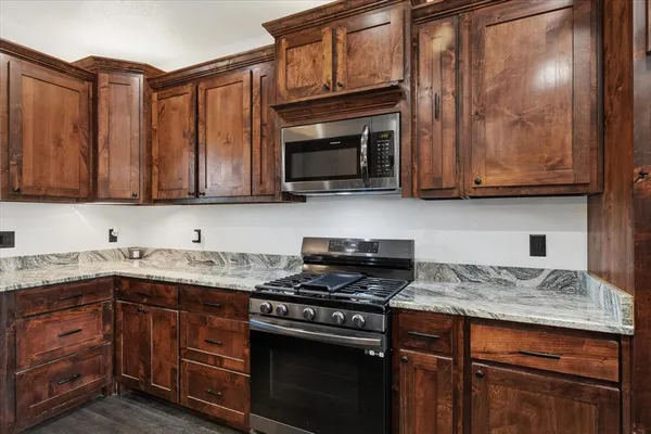 a kitchen with granite countertop cabinets stainless steel appliances and a sink