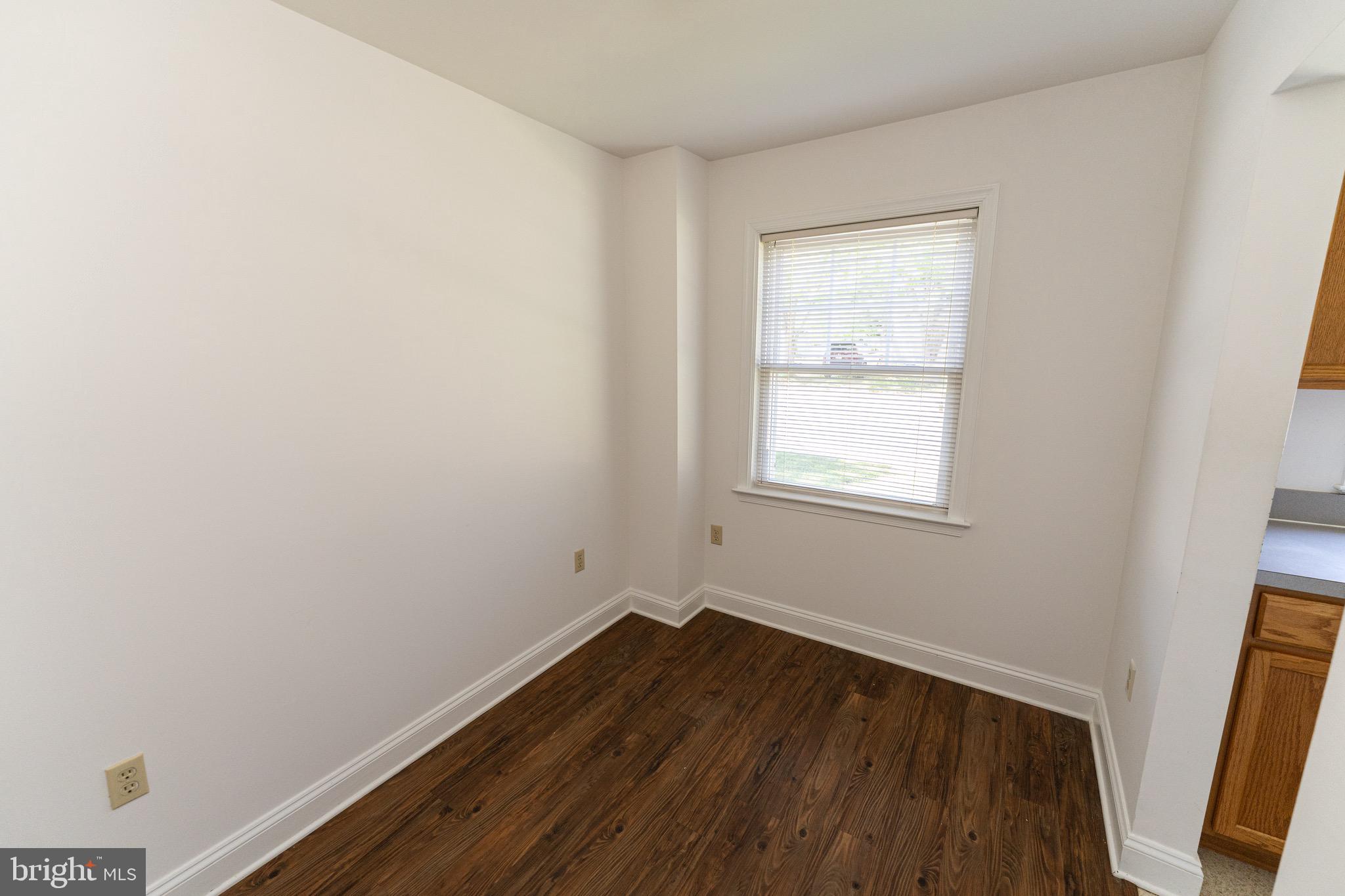 804 Travers Street, Unit 2 Cambridge, MD 21613 - Photo 7 of 26 an empty room with wooden floor and windows