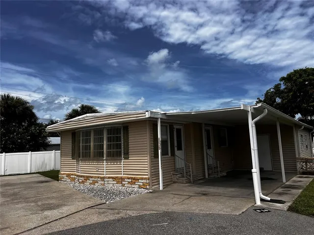 a view of house with a large window and wooden fence