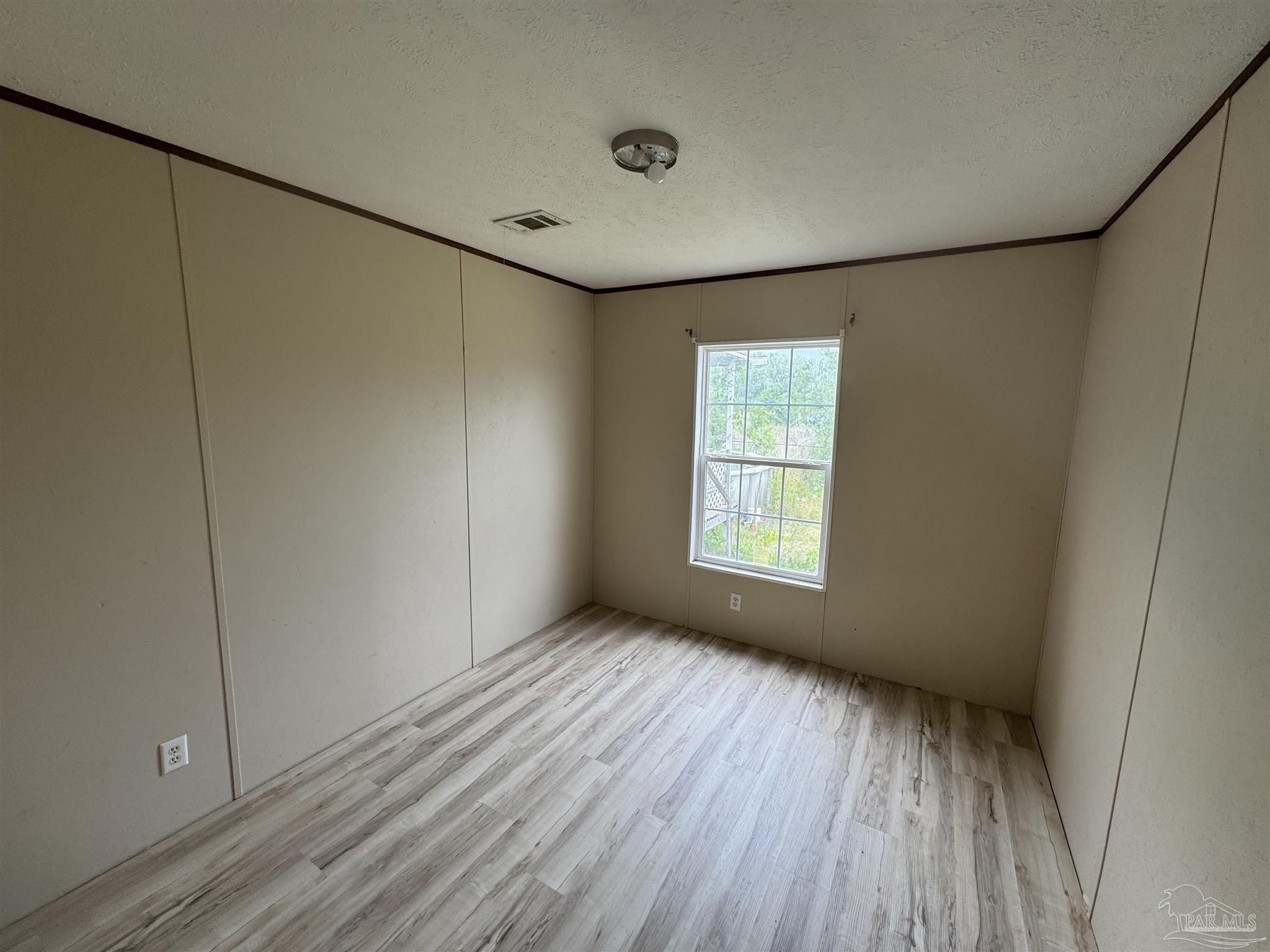 4508 Farm Life Road Milton, FL 32583 - Photo 12 of 20 a view of an empty room with wooden floor and a window