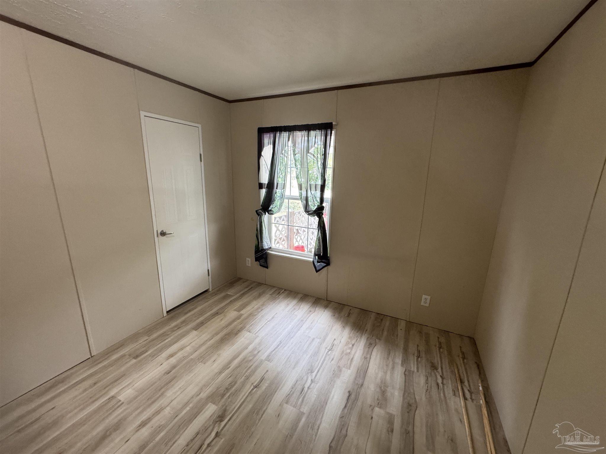 4508 Farm Life Road Milton, FL 32583 - Photo 15 of 20 a view of an empty room with wooden floor and a window