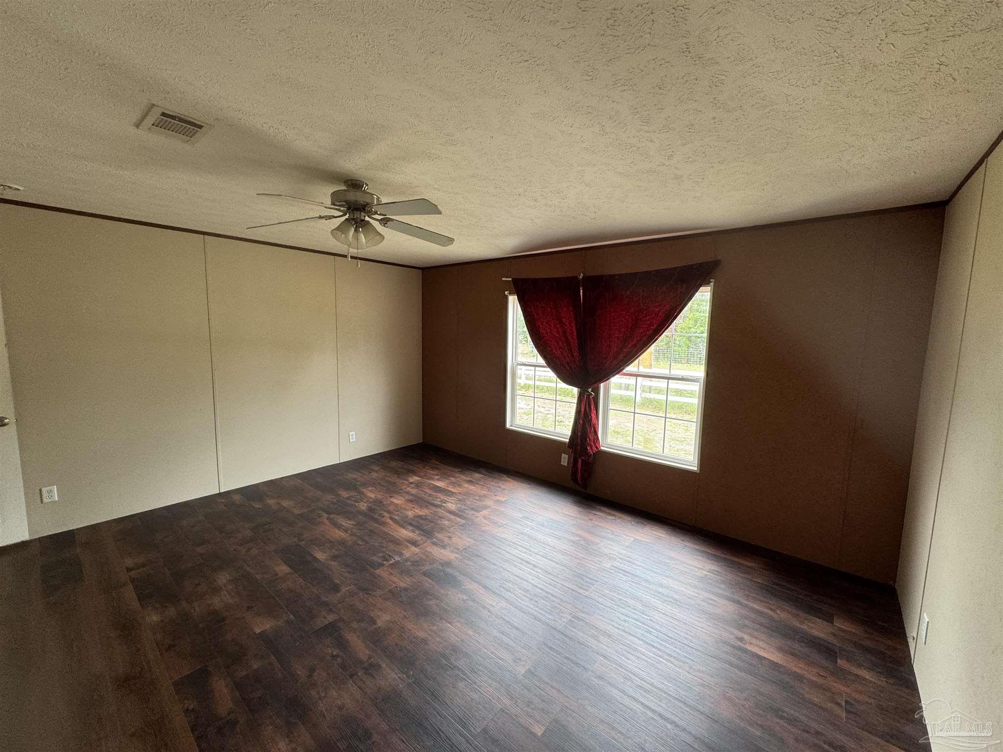 4508 Farm Life Road Milton, FL 32583 - Photo 19 of 20 wooden floor in an empty room with a window