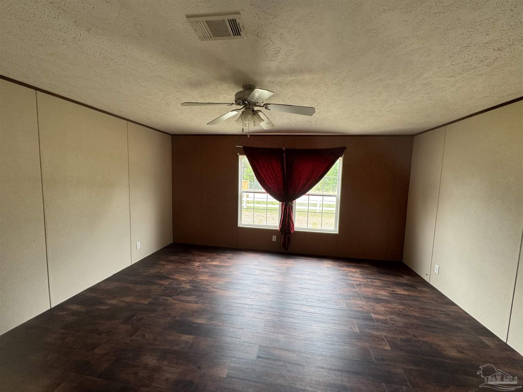 4508 Farm Life Road Milton, FL 32583 - Photo 3 of 20 an empty room with windows and chandelier fan