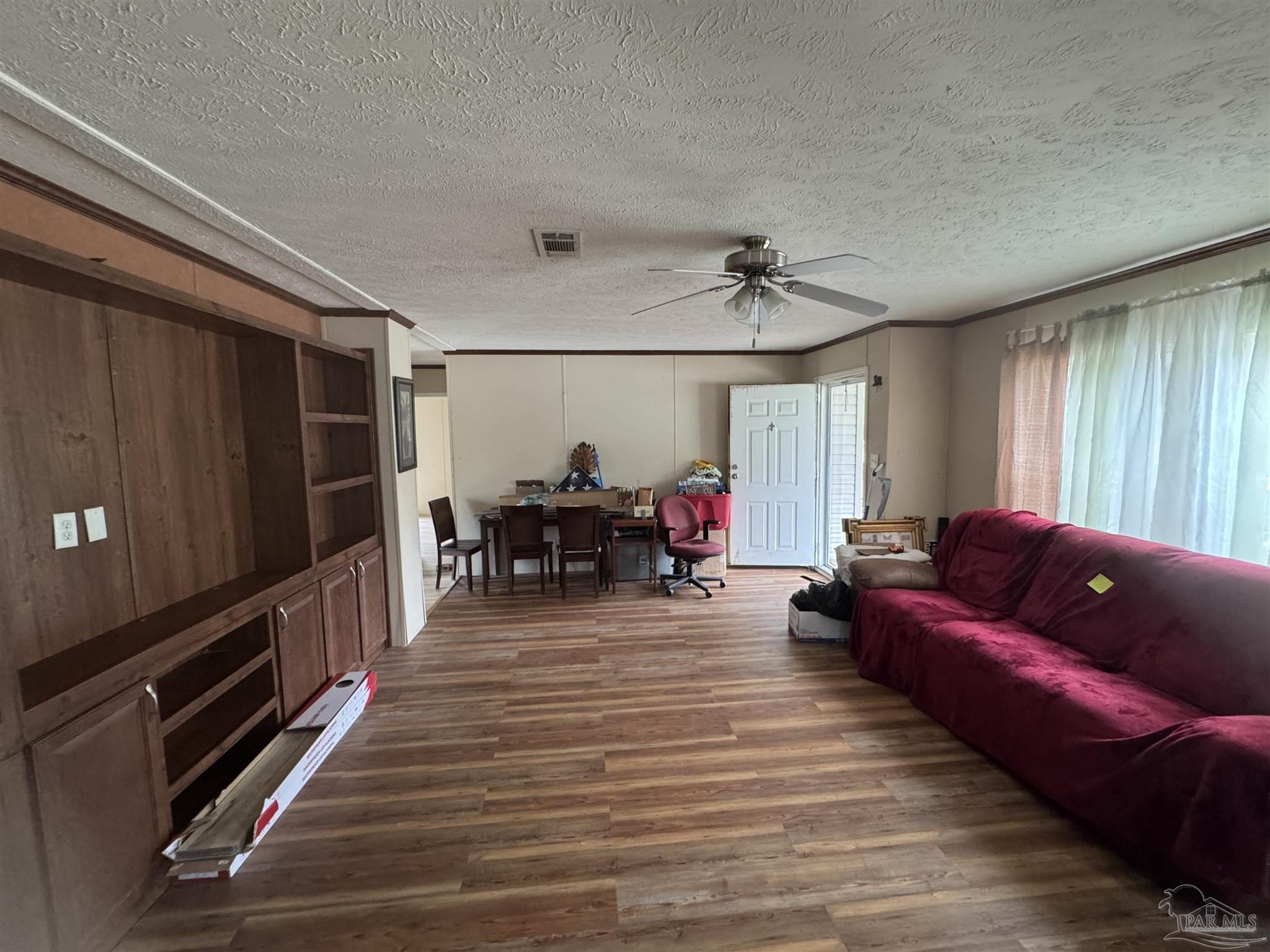 4508 Farm Life Road Milton, FL 32583 - Photo 9 of 20 a living room with furniture a dining table and a flat screen tv