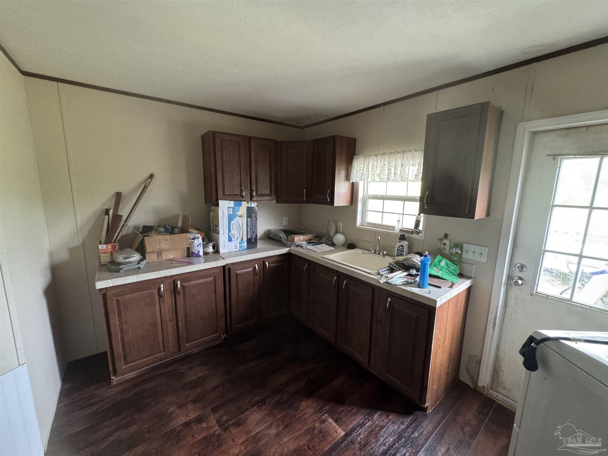 4508 Farm Life Road Milton, FL 32583 - Photo 10 of 20 a kitchen with granite countertop a sink stove and cabinets