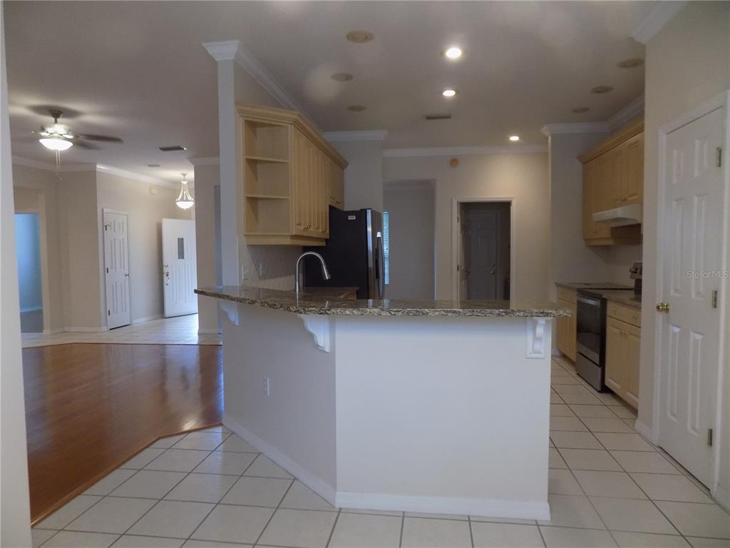 11903 Northwest 9 Road Gainesville, FL 32606 - Photo 18 of 60 a kitchen with stainless steel appliances kitchen island granite countertop a refrigerator and a sink