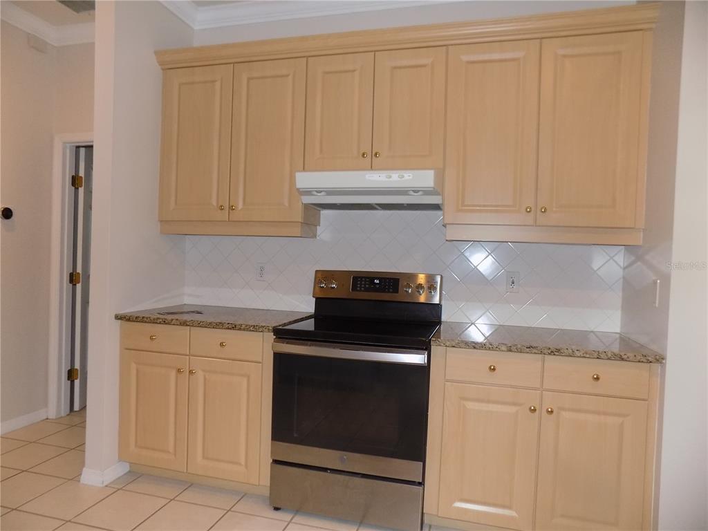 11903 Northwest 9 Road Gainesville, FL 32606 - Photo 24 of 60 a kitchen with granite countertop white cabinets and stainless steel appliances
