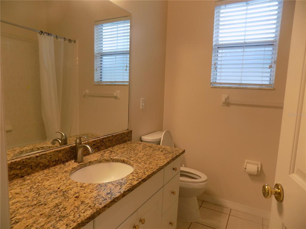 11903 Northwest 9 Road Gainesville, FL 32606 - Photo 41 of 60 a bathroom with a granite countertop sink toilet and a mirror