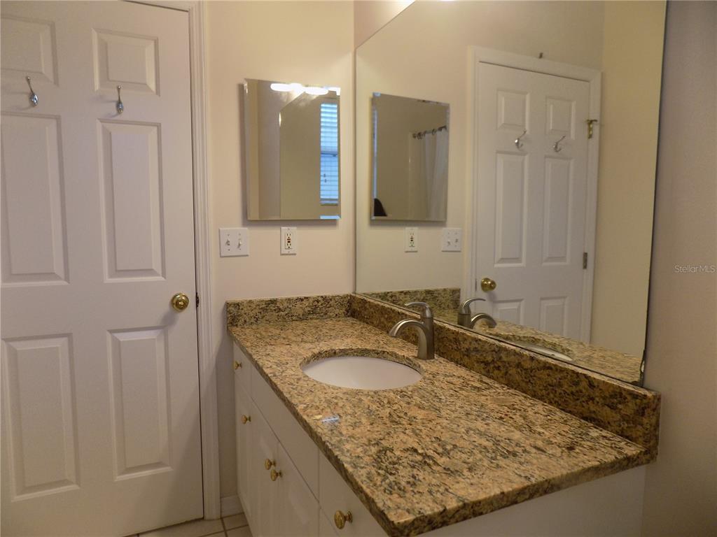 11903 Northwest 9 Road Gainesville, FL 32606 - Photo 42 of 60 a bathroom with a granite countertop sink and a mirror