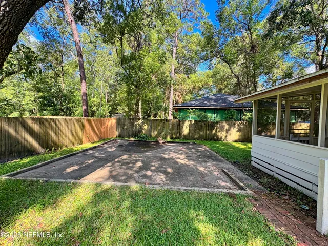 a view of a yard with wooden fence