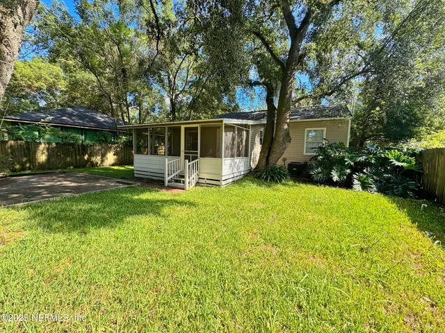 a view of a backyard with sitting area and garden