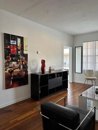 a living room with chairs and a wooden floor