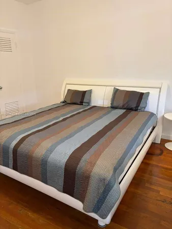 a bedroom with a bed window and a night stand