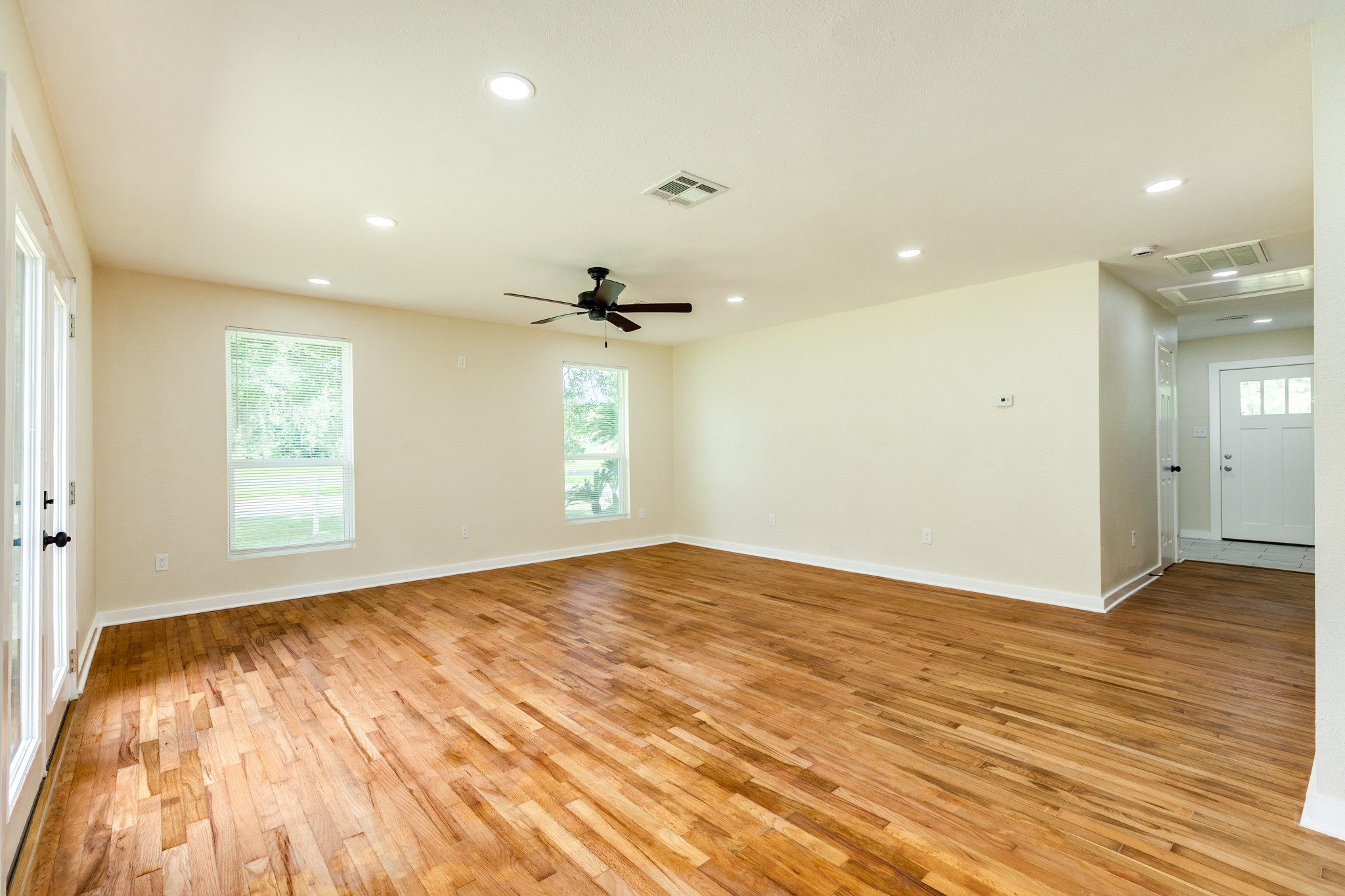 207 Stockman Street Sweeny, TX 77480 - Photo 2 of 22 an empty room with wooden floor and windows