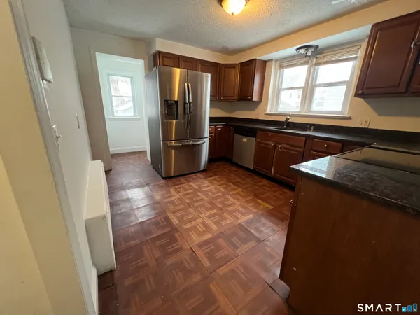a kitchen with stainless steel appliances granite countertop a refrigerator and a sink