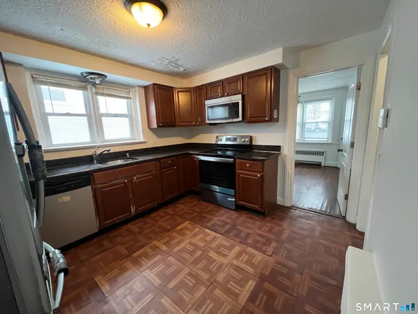 a kitchen with stainless steel appliances granite countertop a sink stove and microwave