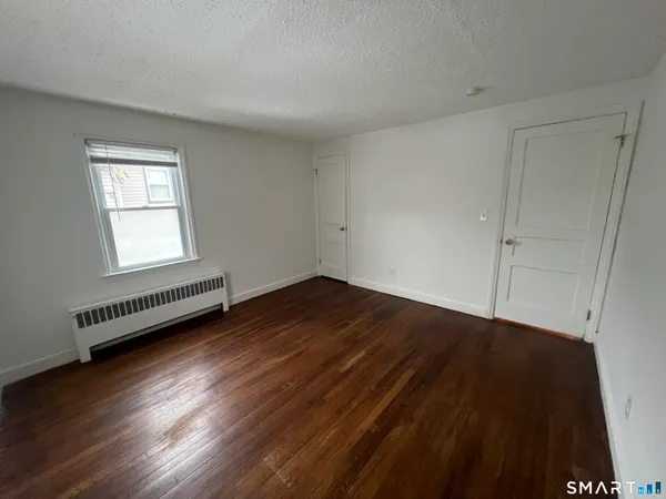 a view of a room with wooden floor and window