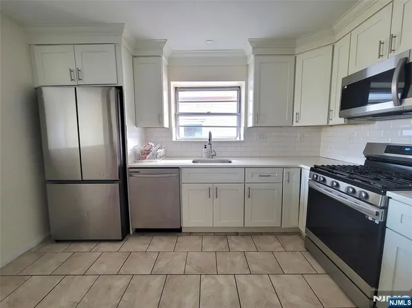 a kitchen with a stove sink and refrigerator