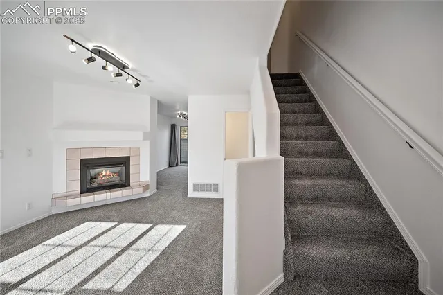 a view of a livingroom with stairs and a fireplace