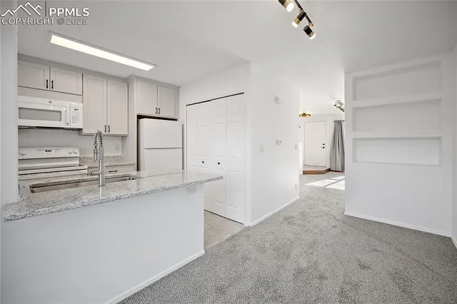a kitchen with stainless steel appliances granite countertop a refrigerator sink and stove