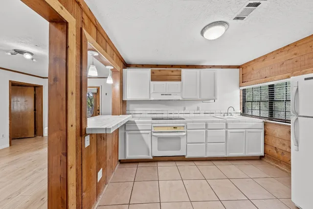 a kitchen with a stove top oven and cabinets