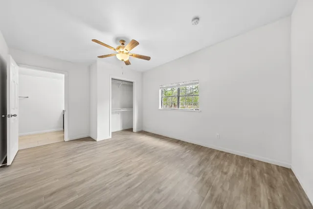 an empty room with a window and a ceiling fan