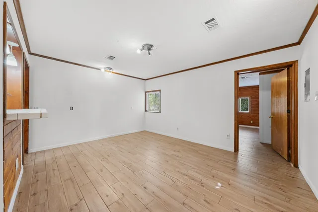 a view of empty room with wooden floor