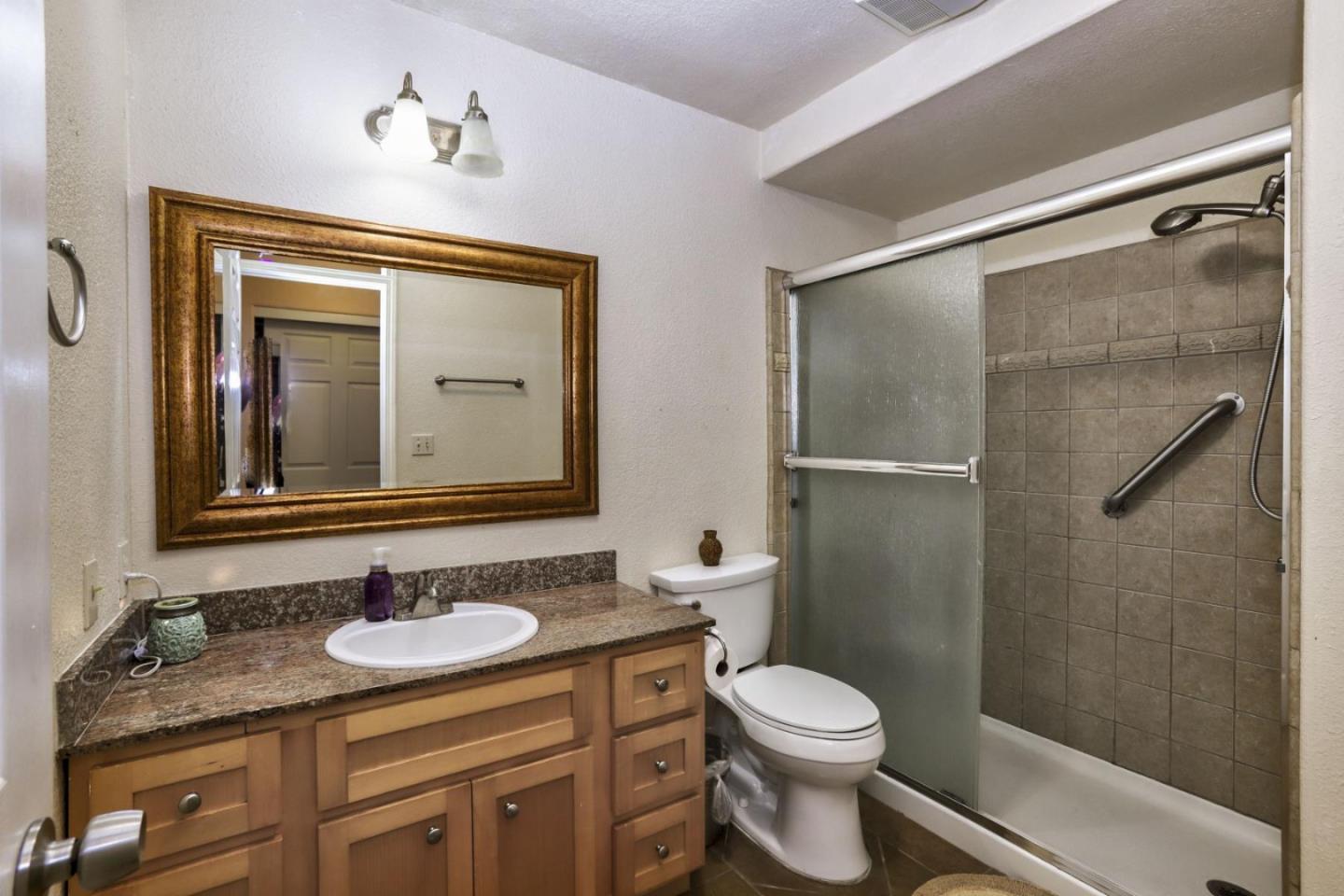 746 Echo Valley Road Salinas, CA 93907 - Photo 19 of 54 a bathroom with a granite countertop sink toilet a mirror and shower