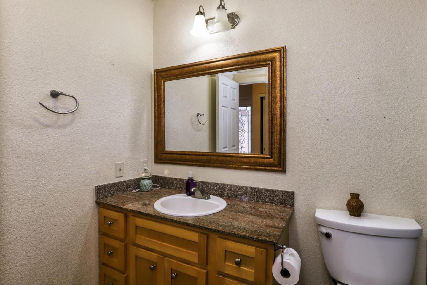 746 Echo Valley Road Salinas, CA 93907 - Photo 20 of 54 a bathroom with a granite countertop toilet a sink and mirror