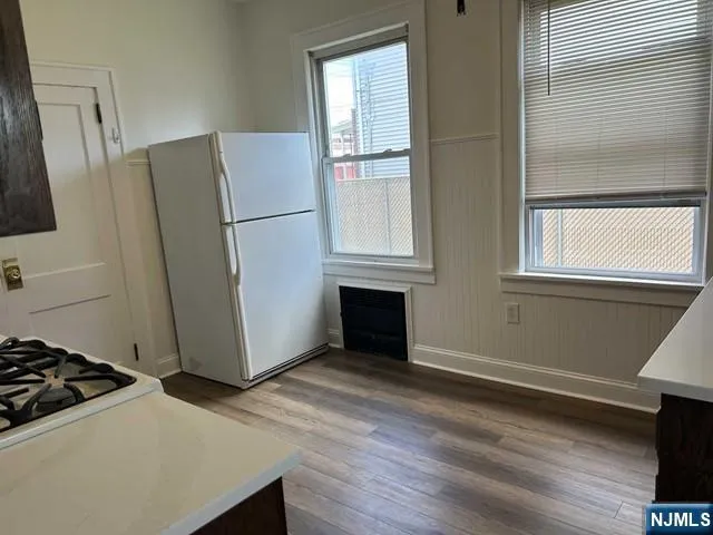 a view of a kitchen with wooden floor and electronic appliances