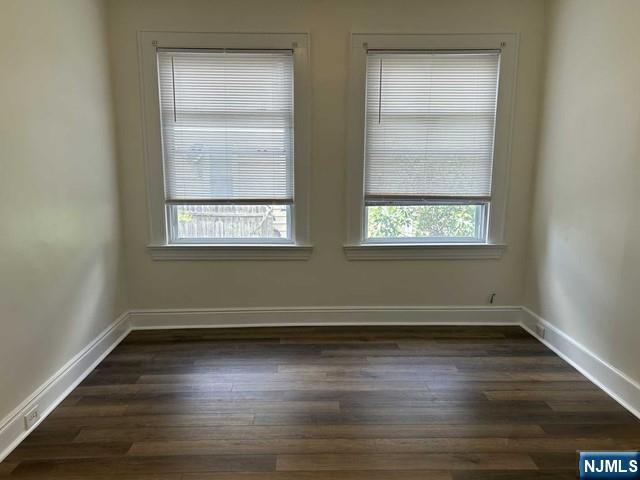 136 Carlton Avenue, Unit 1 East Rutherford, NJ 07073 - Photo 7 of 17 an empty room with wooden floor and windows