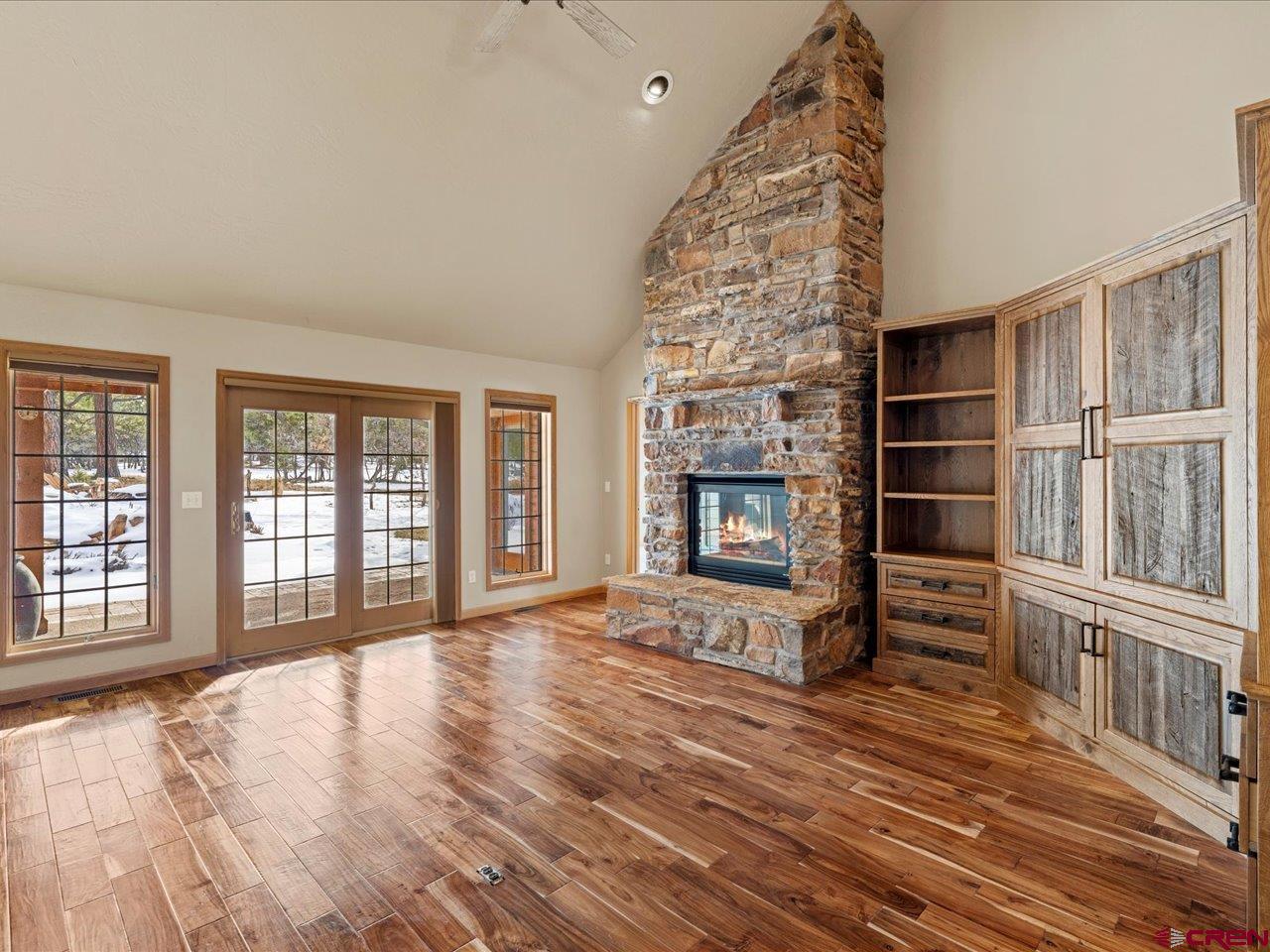 203 Puma Lane Ridgway, CO 81432 - Photo 16 of 43 wooden floor in an empty room with a fireplace and windows