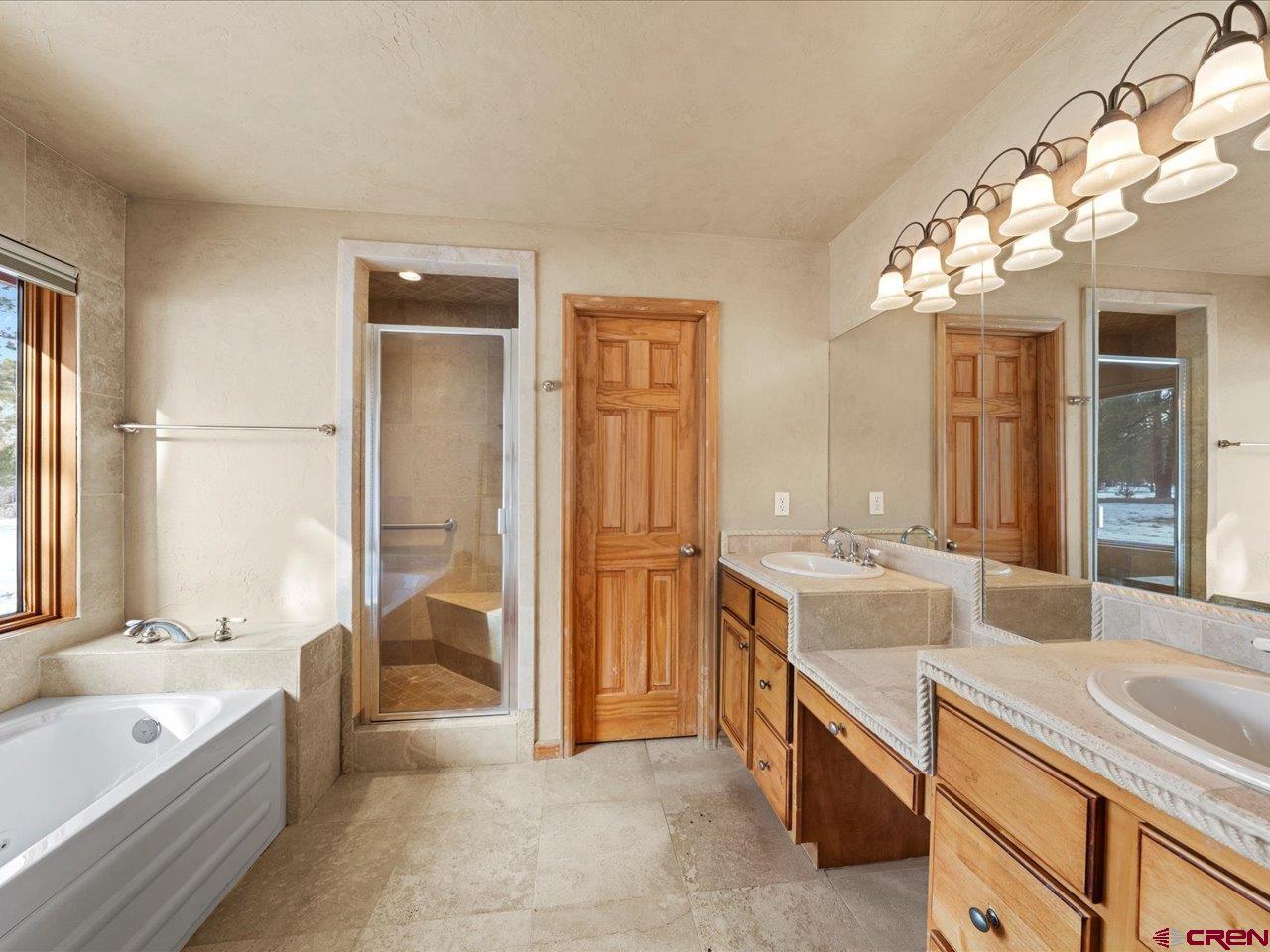 203 Puma Lane Ridgway, CO 81432 - Photo 30 of 43 a spacious bathroom with a granite countertop tub sink and mirror