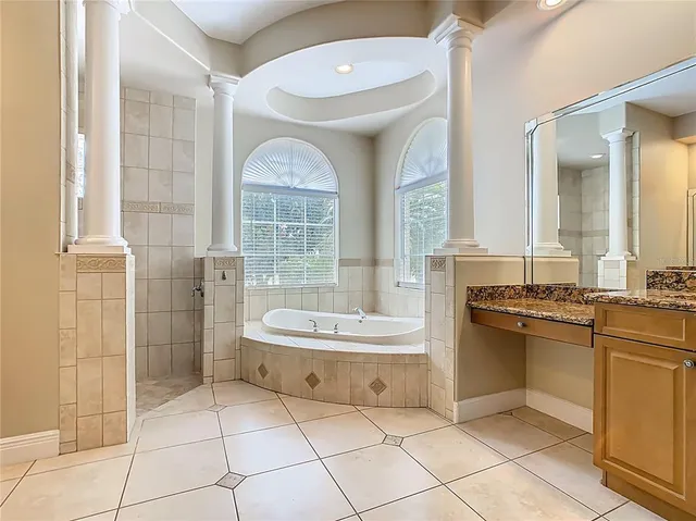 a bathroom with a granite countertop sink a mirror and a shower