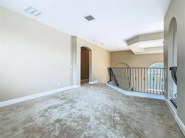 an empty room with windows and ceiling fan