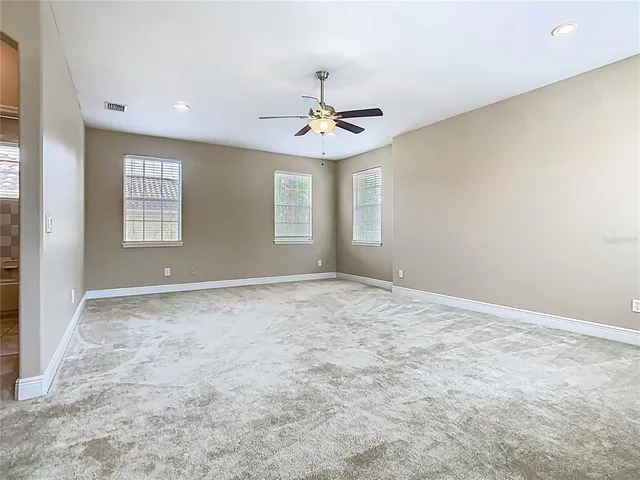 an empty room with closet and windows