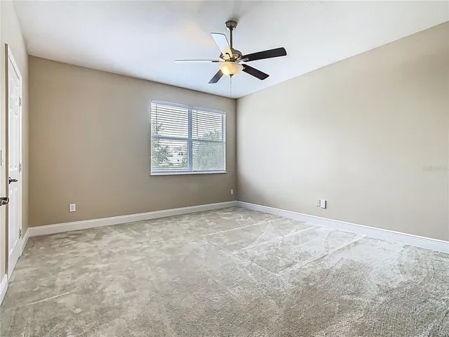 a very nice looking yard with a large window and ceiling fan