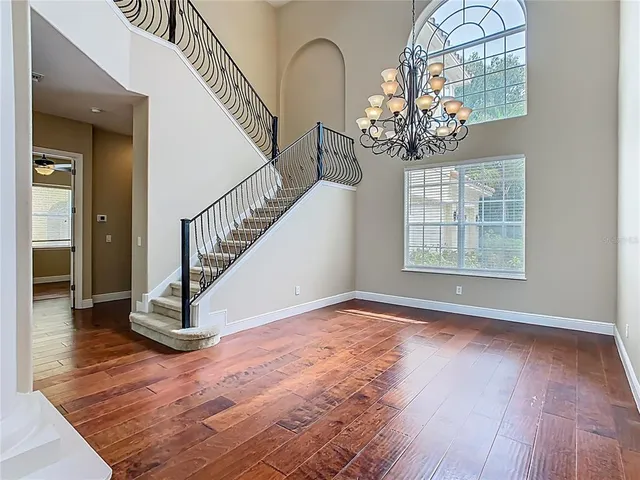 a view of a room with wooden floor potted plant and windows