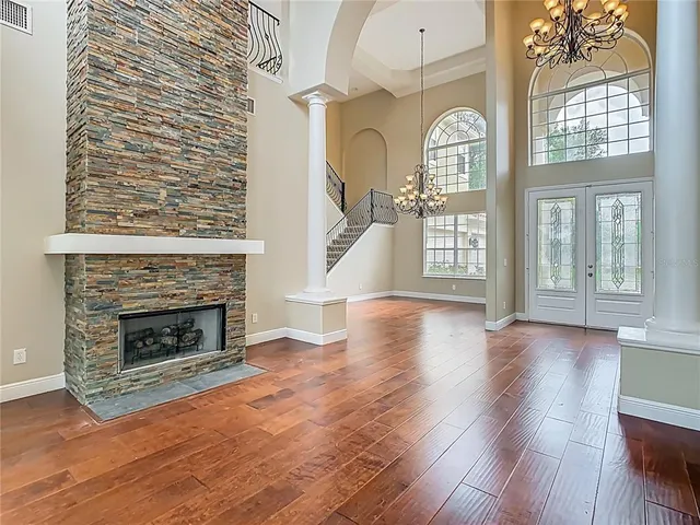 wooden floor fireplace and windows in an empty room