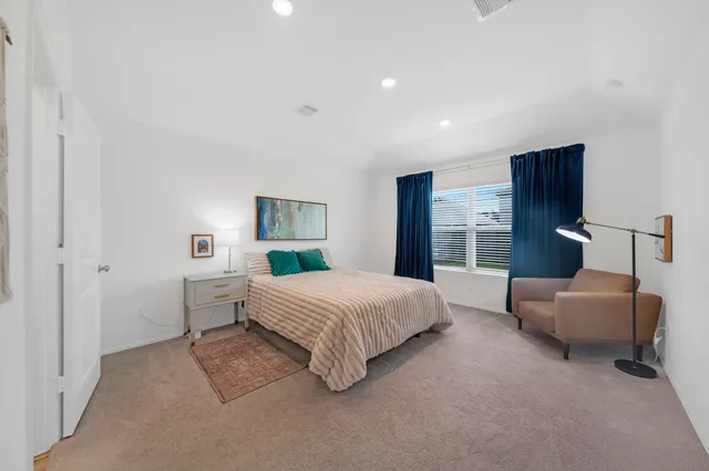 a spacious bedroom with a bed and a couch