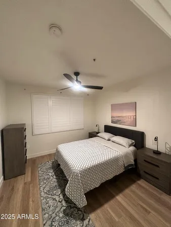 a bedroom with a bed and wooden floor
